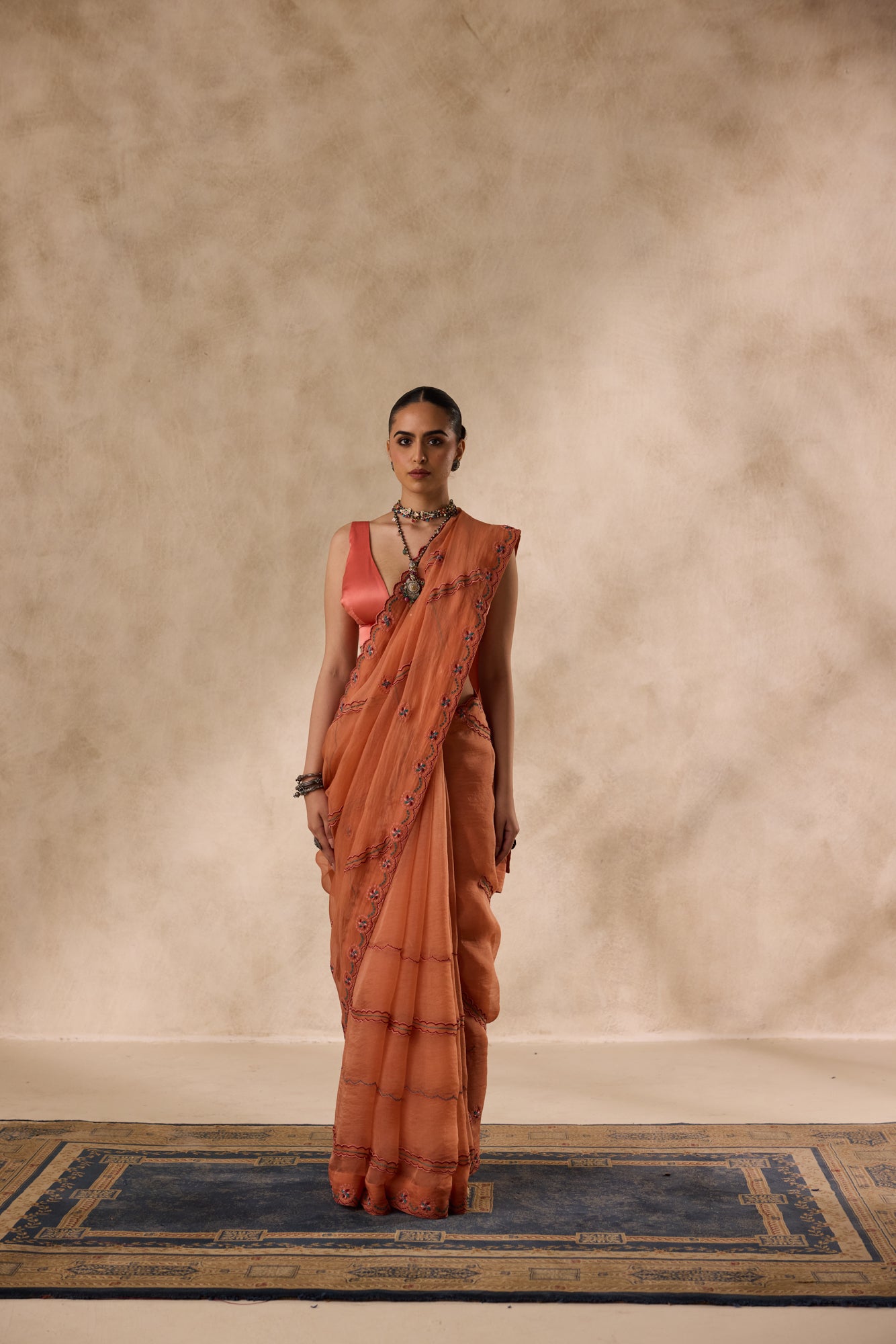 Peach organza scalloped embroidered saree comes with unstitched & unembroidered blouse fabric in chanderi
