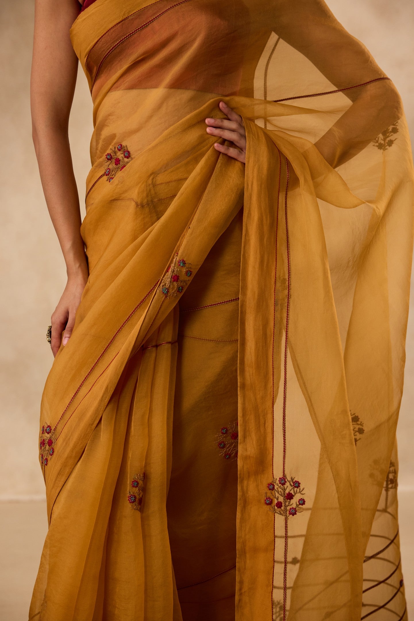 Mustard embroidered organza saree paired with unstitched & unembroidered blouse fabric