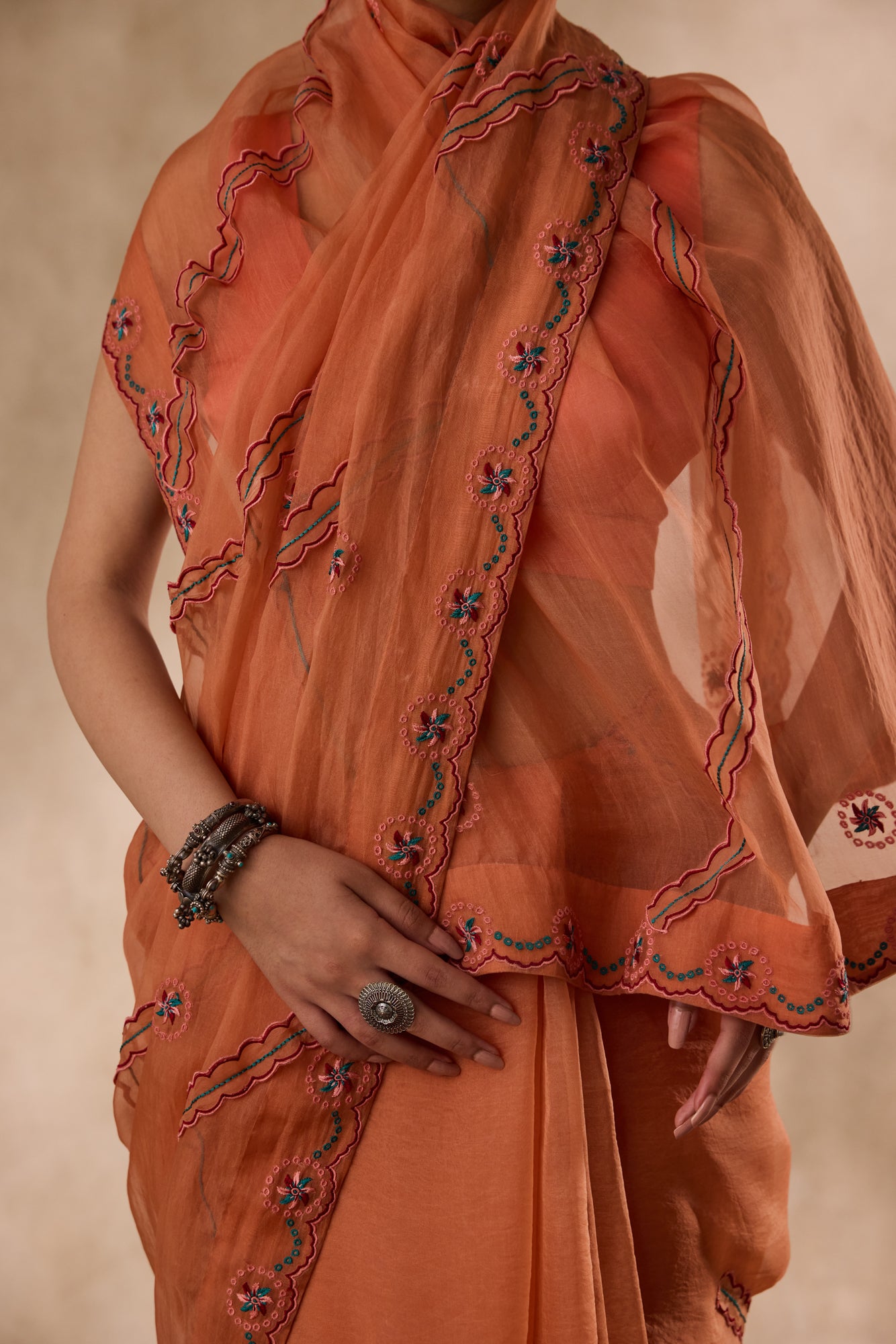 Peach organza scalloped embroidered saree comes with unstitched & unembroidered blouse fabric in chanderi